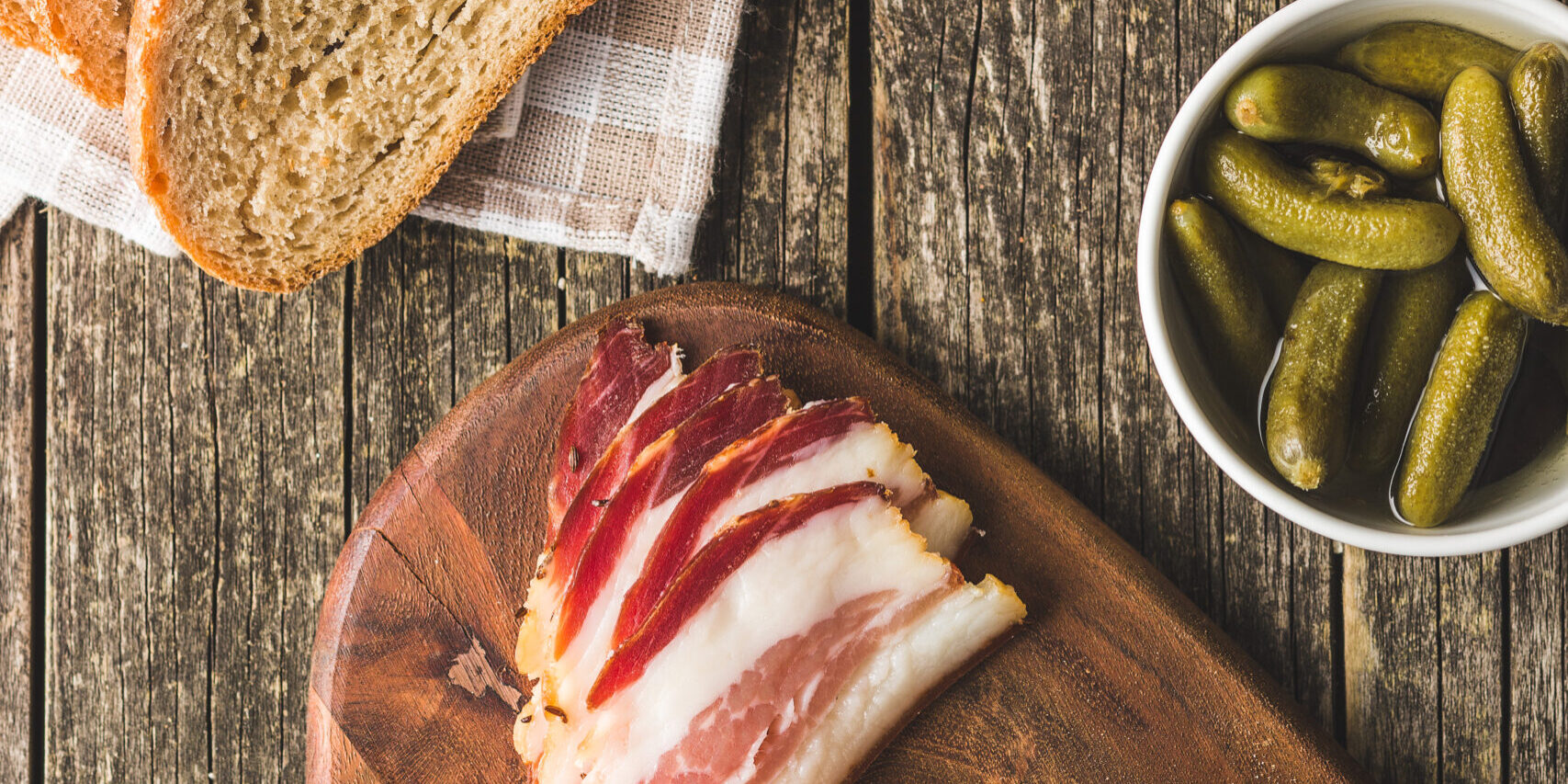 Sliced smoked bacon on cutting board. Top view.